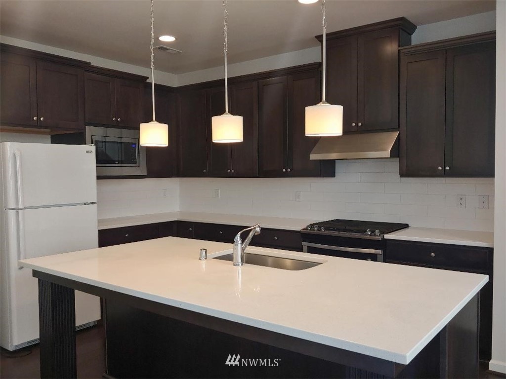 4422 185th Place Southeast Bothell, WA 98012 - Photo 5 of 28 a kitchen with a sink a refrigerator and cabinets