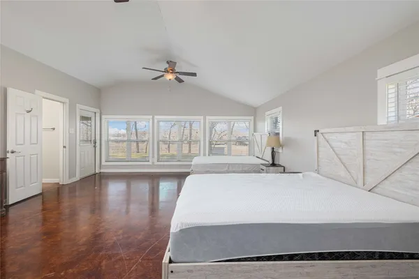 a spacious bedroom with a large bed and a chandelier