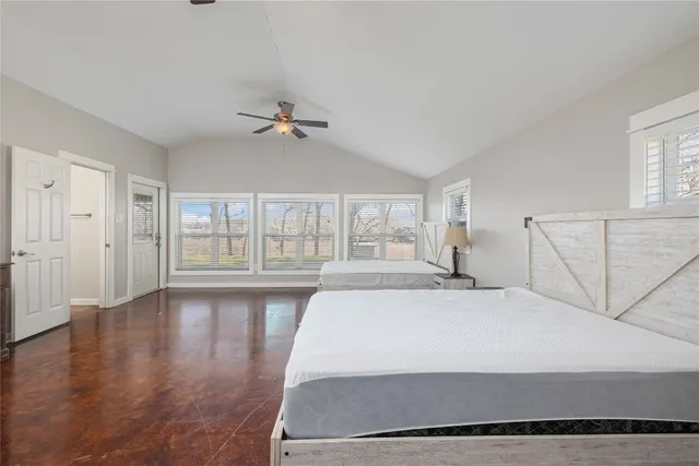 a spacious bedroom with a large bed and a chandelier