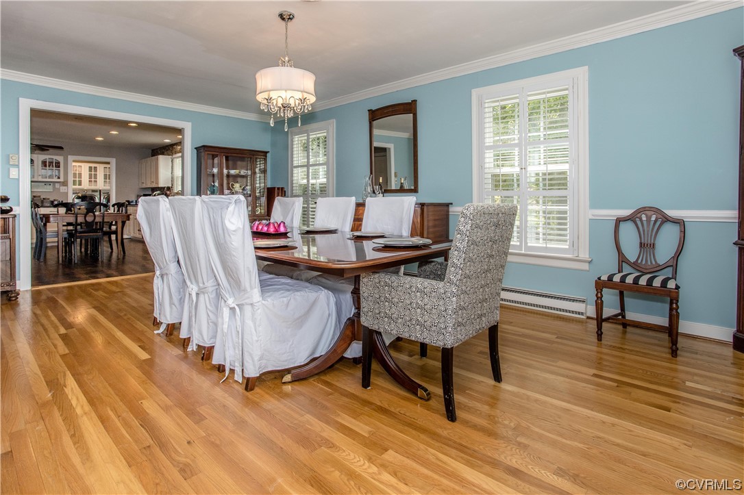 3911 Cresthill Road Chester, VA 23831 - Photo 39 of 50 a dining room with furniture a chandelier and wooden floor