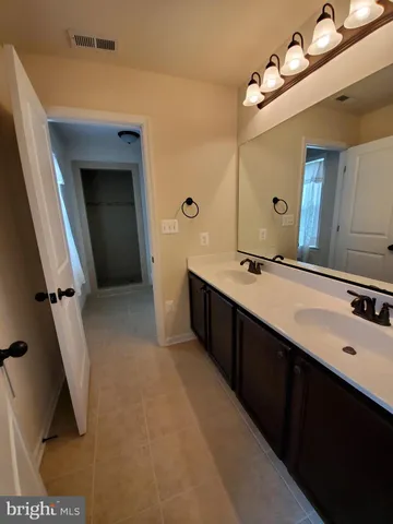 a bathroom with a double vanity sink a mirror and shower