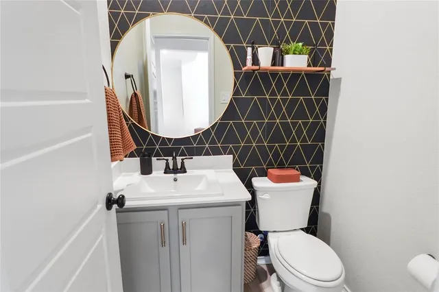 a bathroom with a sink toilet and a mirror