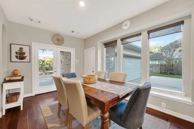 a view of a dining room and livingroom with furniture wooden floor a chandelier