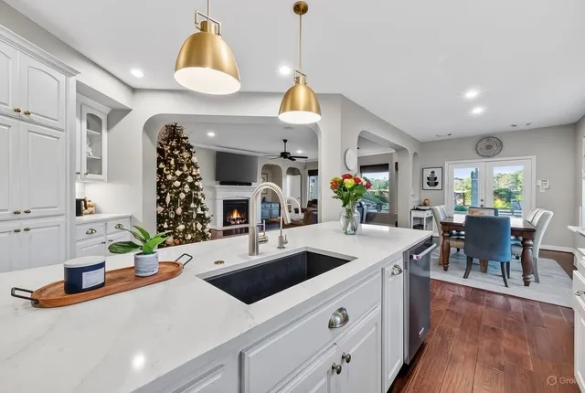a kitchen with stainless steel appliances granite countertop a stove a sink and white cabinets