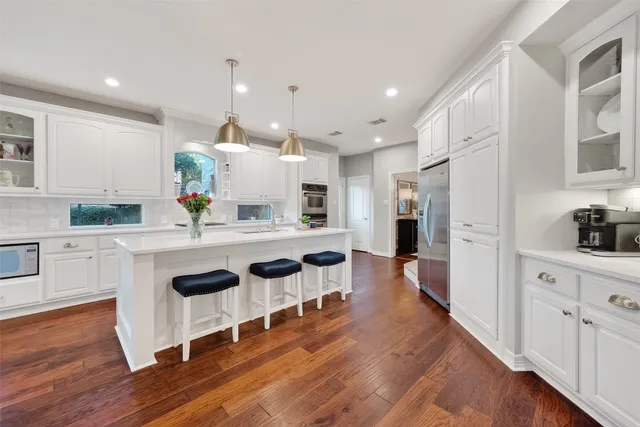 a kitchen with kitchen island granite countertop a sink and cabinets