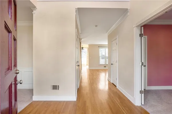 a view of a hallway with wooden floor and closet area