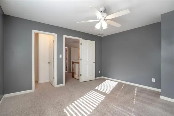 a view of an empty room with kitchen and a window