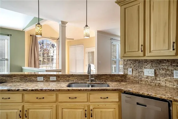 a large kitchen with kitchen island a large counter space a sink appliances and cabinets