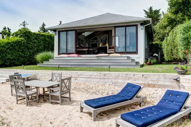 a view of a patio with table and chairs with plants and trees