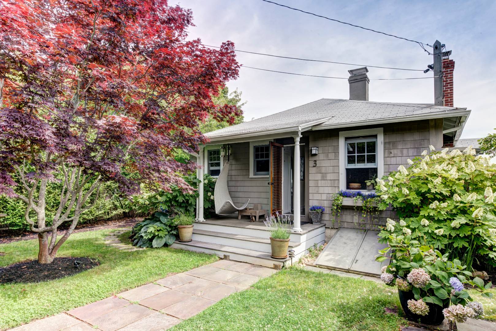 Undisclosed Address Sag Harbor, NY 11963 - Photo 6 of 16 a front view of a house with a garden