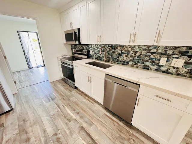 a kitchen with a sink a stove and cabinets