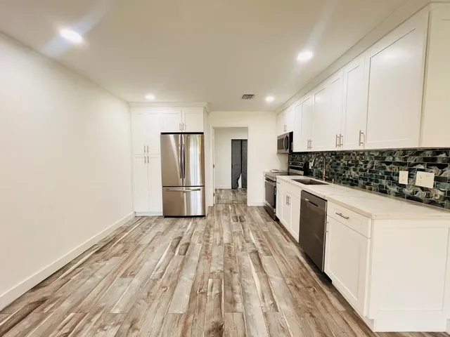 a kitchen with stainless steel appliances granite countertop a stove a sink and a refrigerator