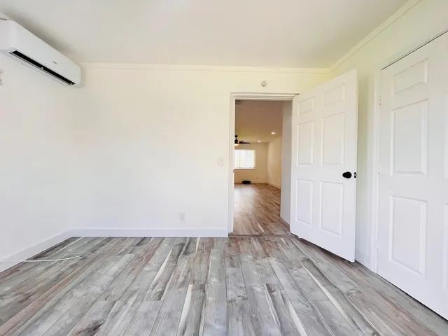 a view of a room with wooden floor and a bathroom