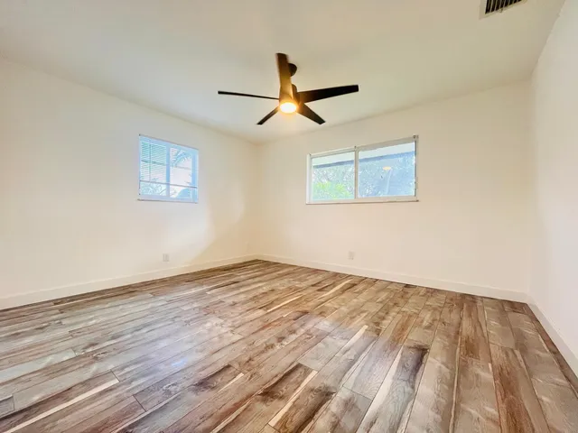 a view of empty room with wooden floor