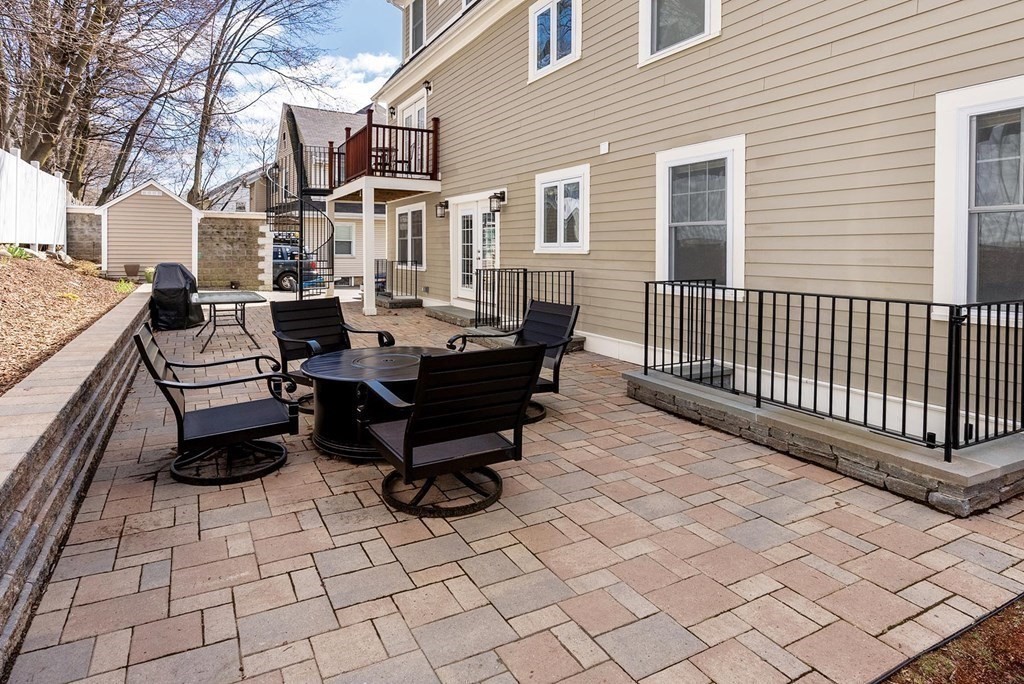 77 Beaconsfield Road, Unit 77 Brookline, MA 02445 - Photo 21 of 21 a backyard of a house with barbeque oven and a bench