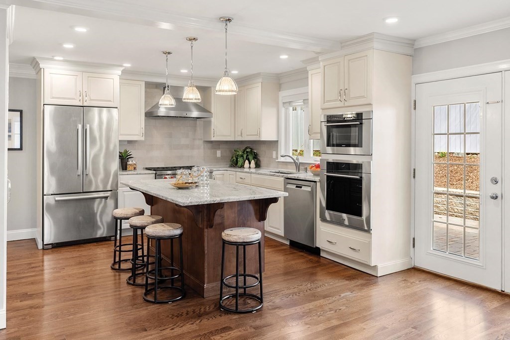 77 Beaconsfield Road, Unit 77 Brookline, MA 02445 - Photo 5 of 21 a kitchen with stainless steel appliances granite countertop a table chairs stove microwave and a refrigerator