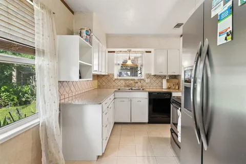 a view of kitchen with wooden floor and electronic appliances