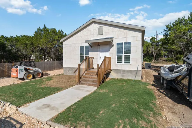 a view of a house with backyard and sitting area