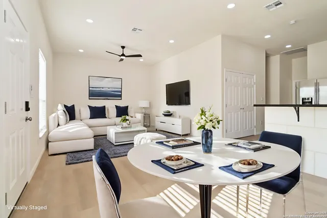 a living room with furniture a flat screen tv and kitchen view