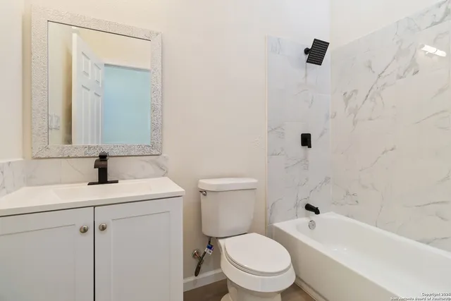 a bathroom with a sink toilet vanity and tub
