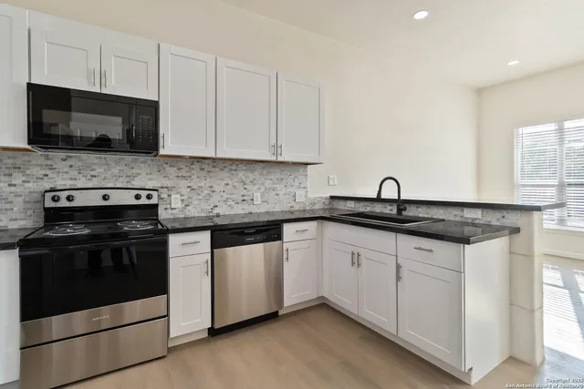 a kitchen with stainless steel appliances granite countertop a sink stove and microwave