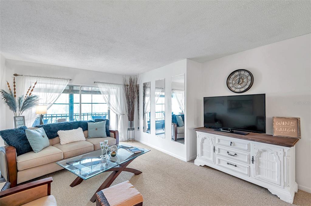 1430 Heather Ridge Boulevard, Unit 304 Dunedin, FL 34698 - Photo 14 of 36 a living room with furniture and a flat screen tv