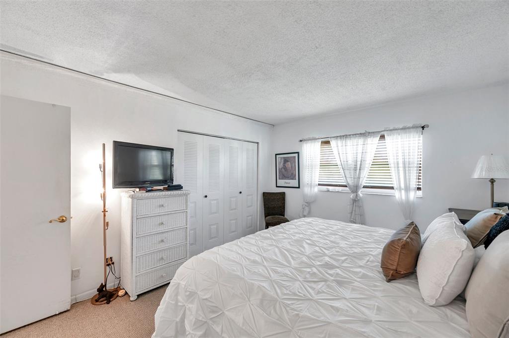 1430 Heather Ridge Boulevard, Unit 304 Dunedin, FL 34698 - Photo 16 of 36 a bedroom with a bed and a television