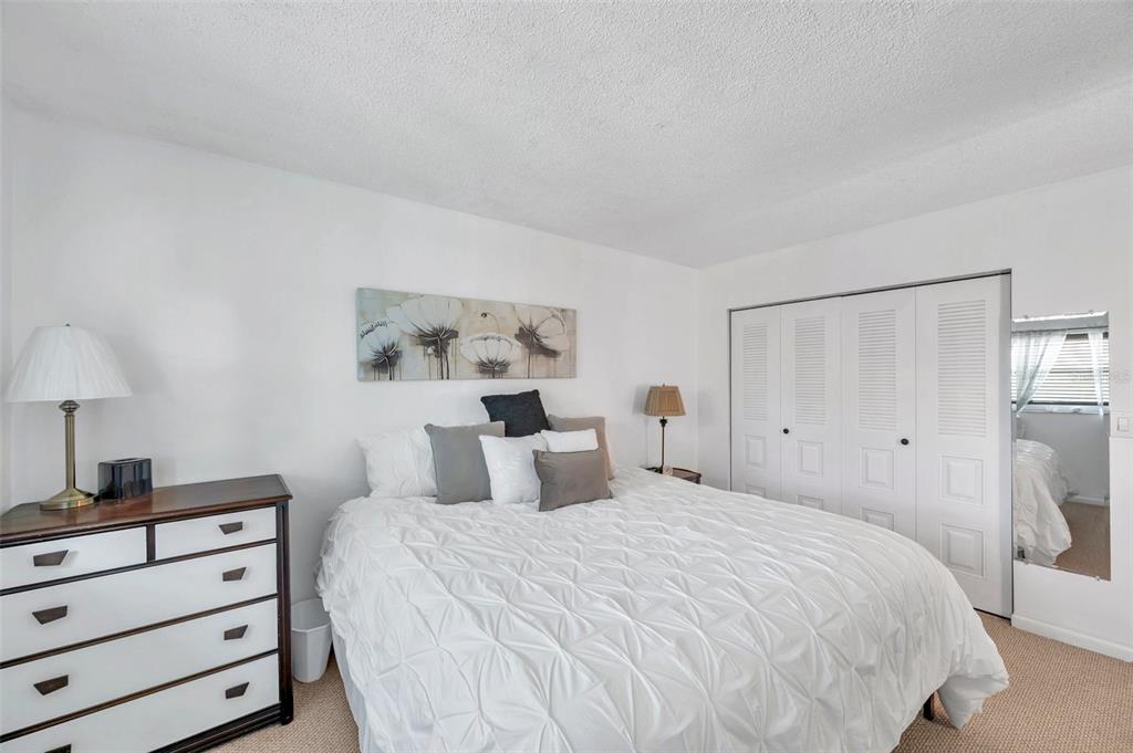 1430 Heather Ridge Boulevard, Unit 304 Dunedin, FL 34698 - Photo 17 of 36 a bedroom with a bed and a night stand