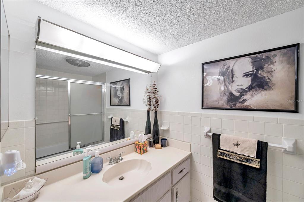 1430 Heather Ridge Boulevard, Unit 304 Dunedin, FL 34698 - Photo 20 of 36 a bathroom with a sink a vanity and a mirror