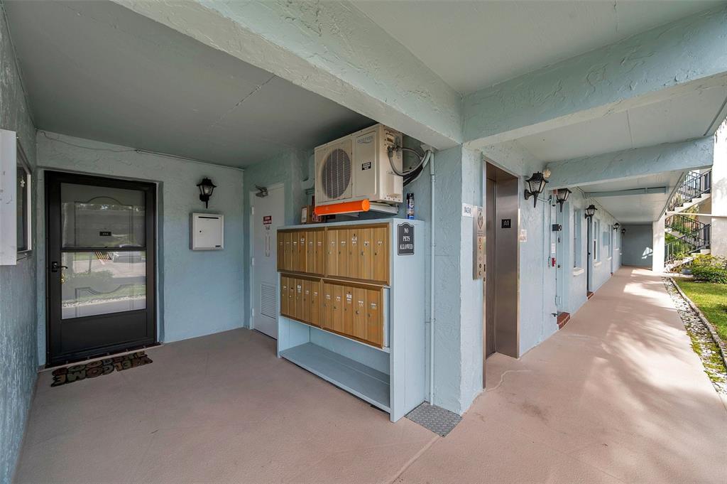 1430 Heather Ridge Boulevard, Unit 304 Dunedin, FL 34698 - Photo 3 of 36 a view of hallway with wooden floor and cabinet