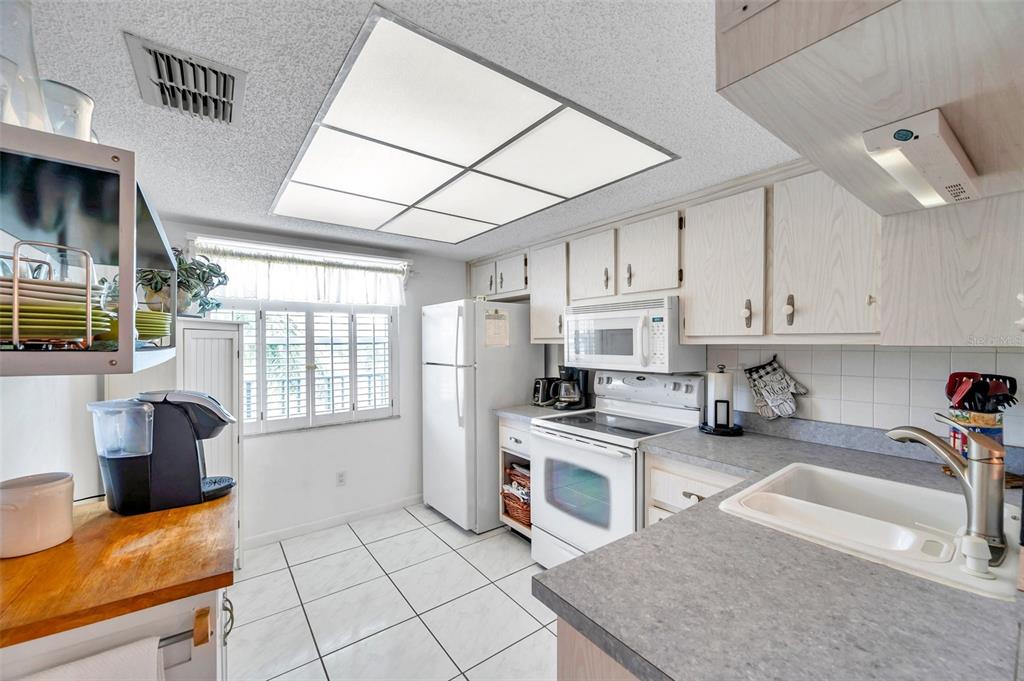 1430 Heather Ridge Boulevard, Unit 304 Dunedin, FL 34698 - Photo 7 of 36 a kitchen with stainless steel appliances granite countertop a stove top oven a sink a counter space and cabinets