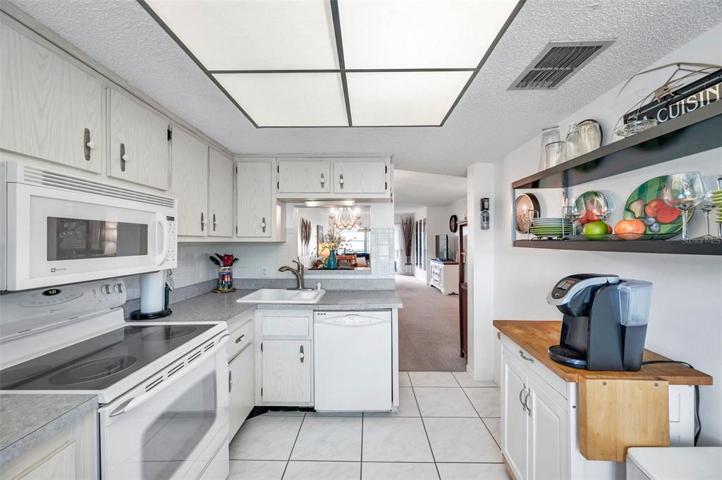 1430 Heather Ridge Boulevard, Unit 304 Dunedin, FL 34698 - Photo 9 of 36 a kitchen with stainless steel appliances granite countertop a sink and cabinets
