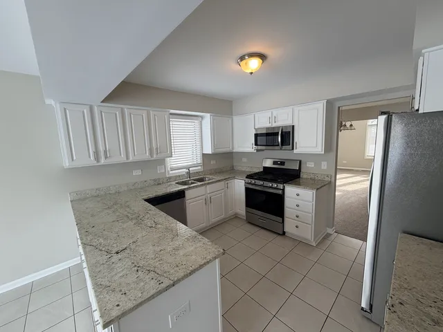 a kitchen with granite countertop a refrigerator and a sink