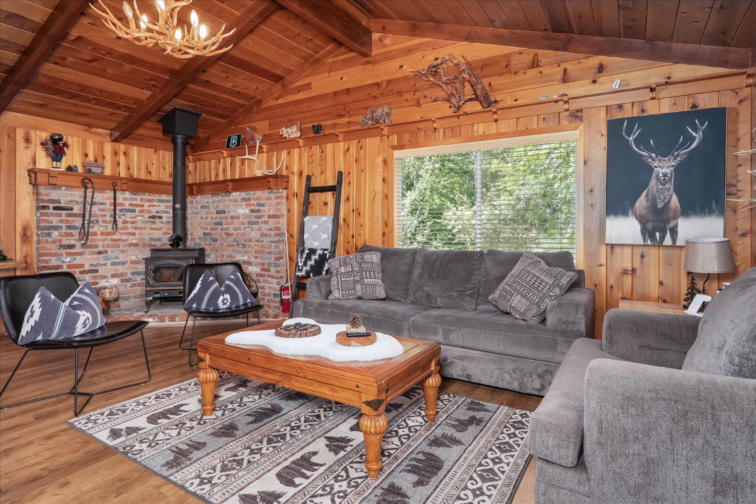 44800 Mountain Meadow Road Oakhurst, CA 93644 - Photo 5 of 41 a living room with furniture a rug and a chandelier