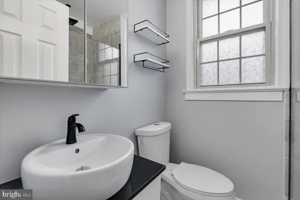 a bathroom with a toilet a sink and mirror