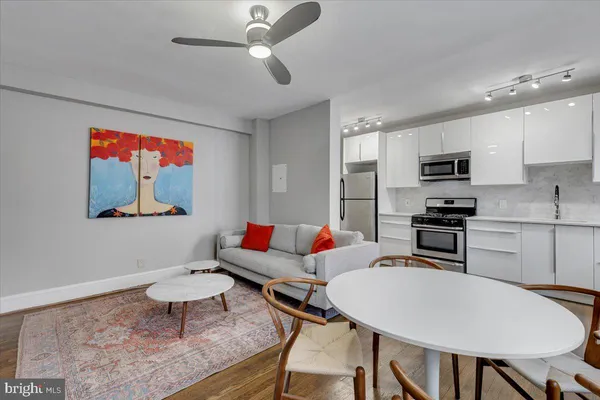 a living room with stainless steel appliances kitchen island granite countertop furniture and a refrigerator