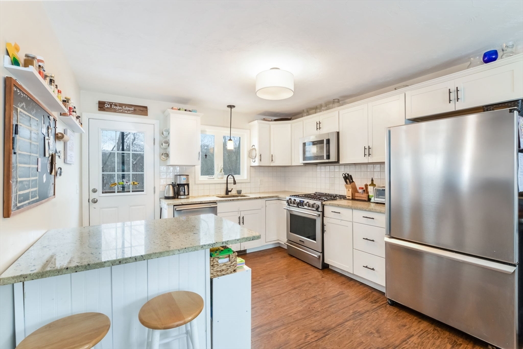 63 Wareham Street Middleboro, MA 02346 - Photo 6 of 23 a kitchen with stainless steel appliances granite countertop a refrigerator a stove and a sink with wooden floors