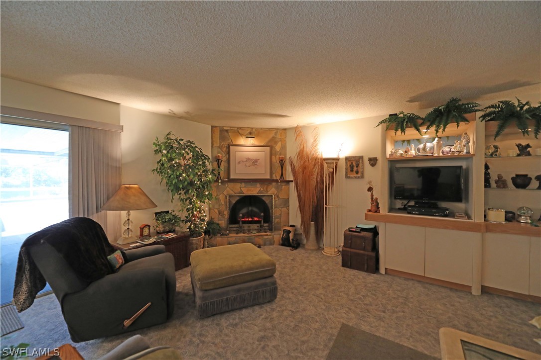 14430 Cemetery Road Fort Myers, FL 33905 - Photo 12 of 35 a living room with furniture a flat screen tv and a fireplace