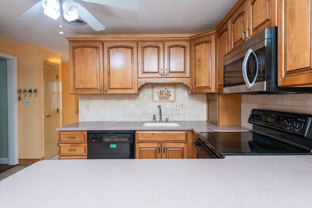 26 Doane Road Medford, MA 02155 - Photo 13 of 24 a kitchen with stainless steel appliances granite countertop a stove a sink and a microwave
