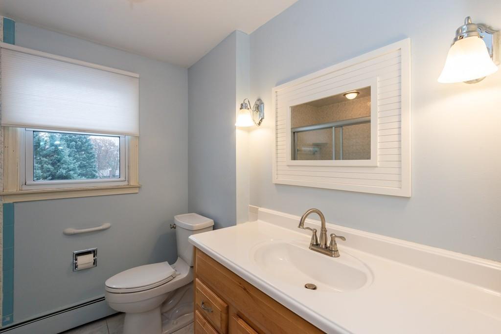 26 Doane Road Medford, MA 02155 - Photo 21 of 24 a bathroom with a toilet a sink a mirror and a window