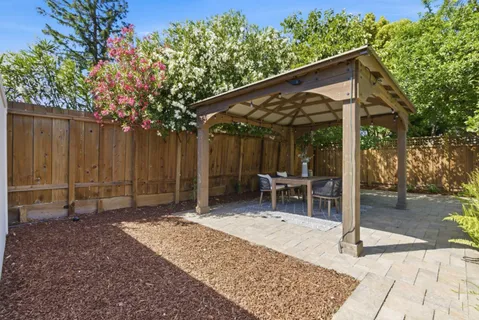 a backyard of a house with barbeque oven table and chairs