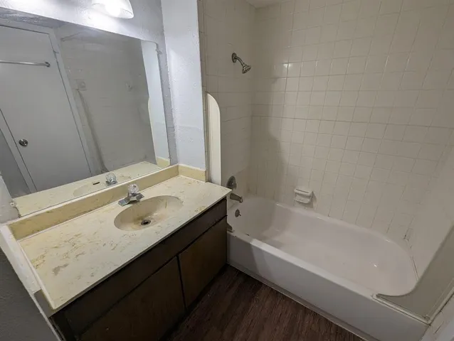a bathroom with a tub sink and mirror