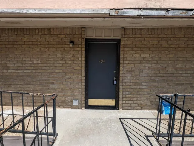 a brick building with a bench and a potted plant