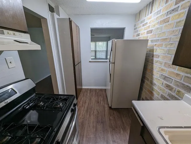 a kitchen with wooden cabinets and a stove top oven