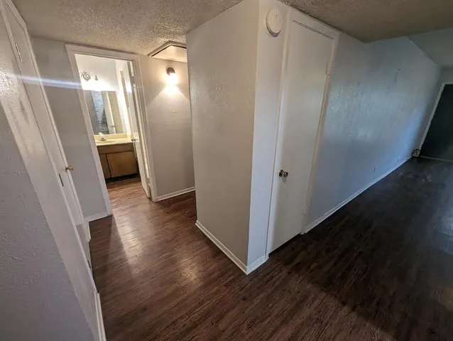 a view of a hallway with wooden floor