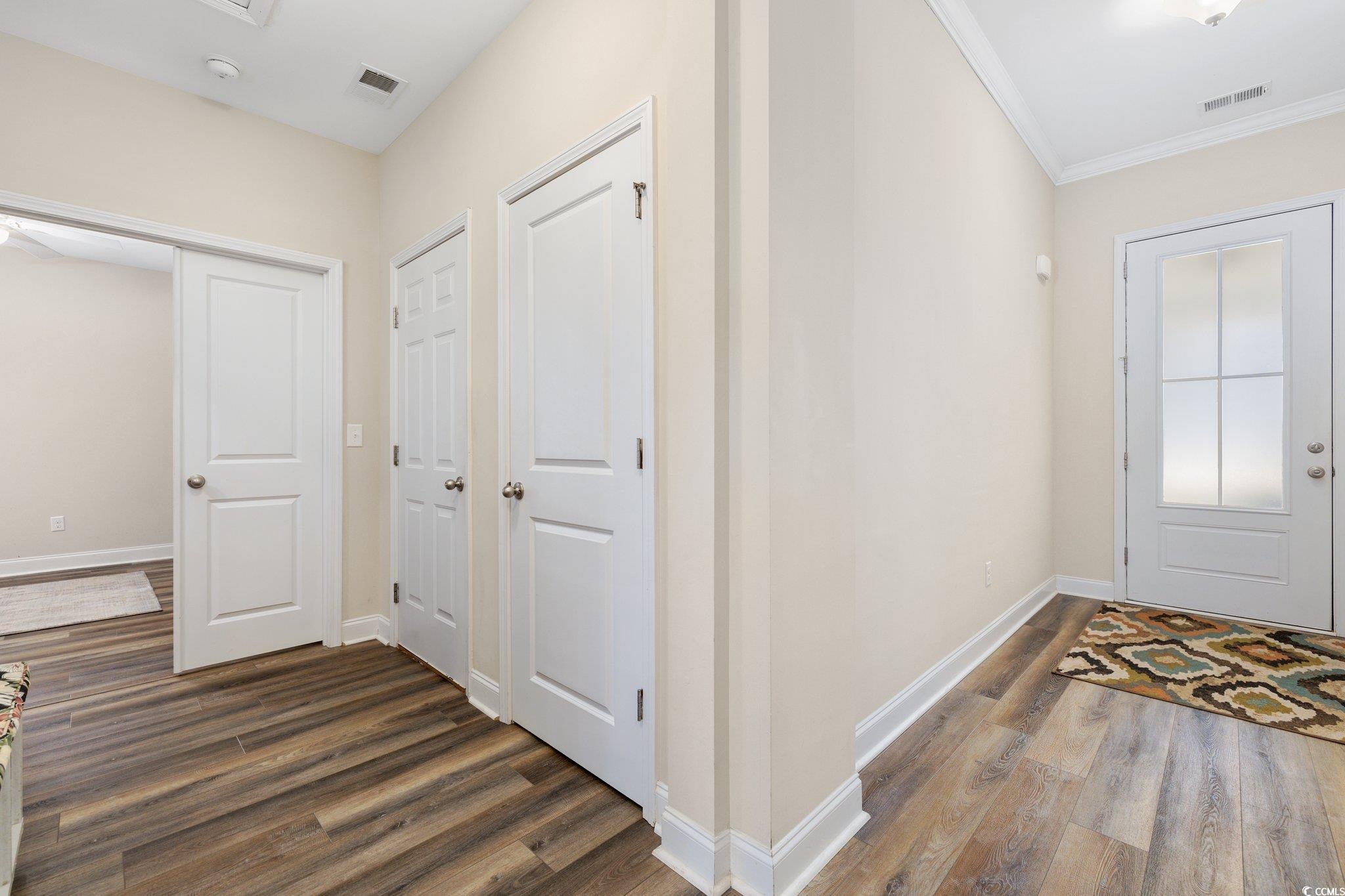 179 Hyacinth Loop Murrells Inlet, SC 29576 - Photo 25 of 40 Foyer with ornamental molding, dark wood-type flooring, and visible vents