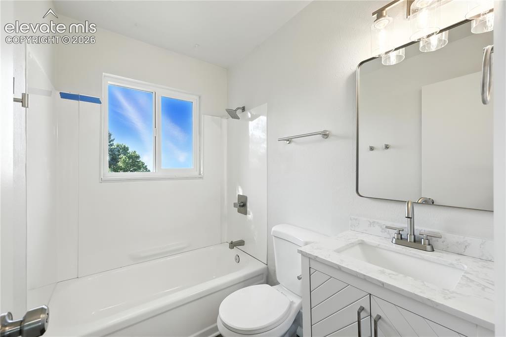 7033 Sequoyah Way Colorado Springs, CO 80915 - Photo 14 of 20 a bathroom with a granite countertop sink toilet and shower