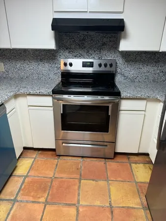 a stove top oven sitting inside of a kitchen