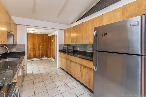 a kitchen with granite countertop a refrigerator and a sink
