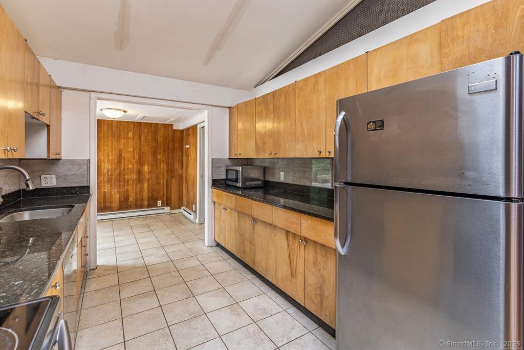 a kitchen with granite countertop a refrigerator and a sink